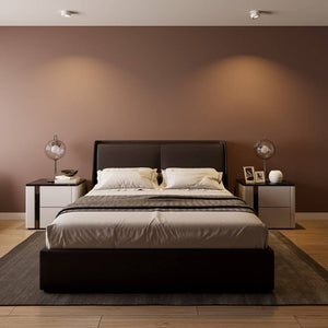 Modern bedroom with black bed frame, cream pillows, and chrome pendant lights against warm taupe wall.
