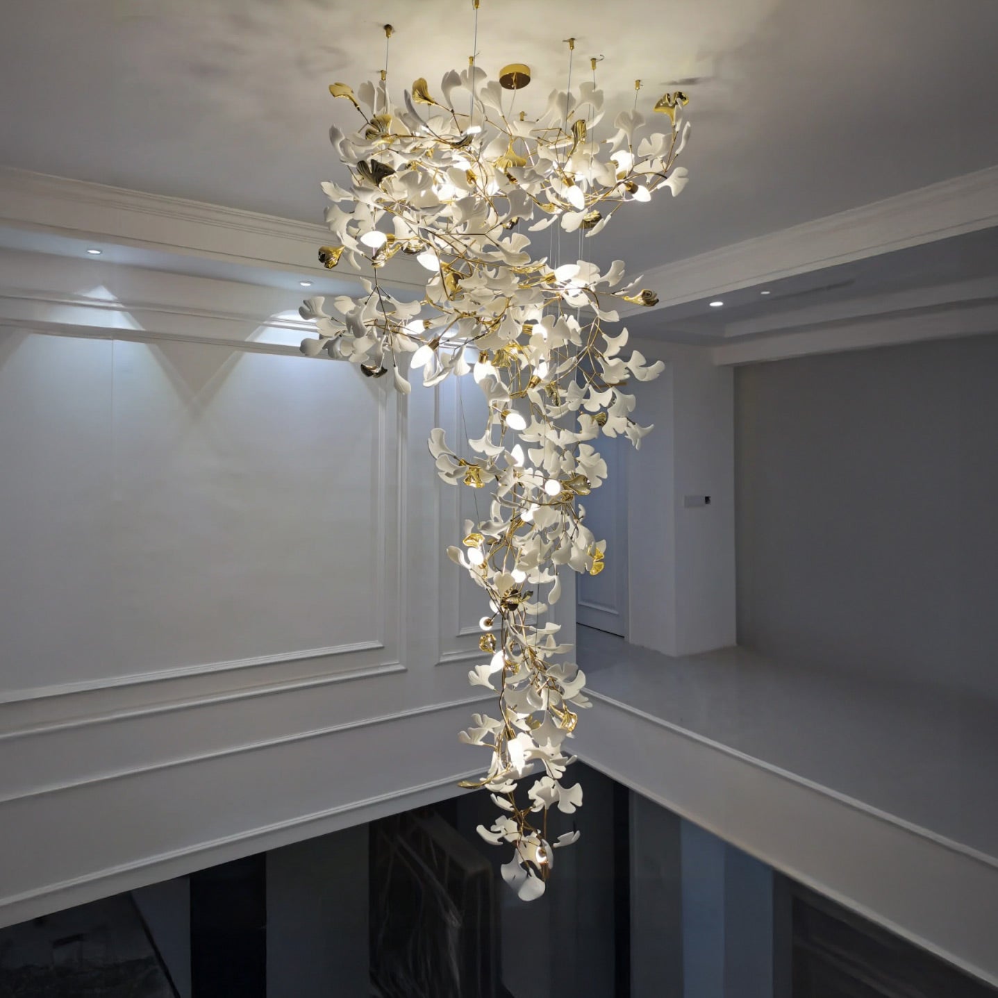 Cascading ceramic chandelier installed in a tall interior opening.