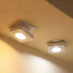 Two square white recessed ceiling lights with bright LED panels mounted in a cream-colored ceiling.