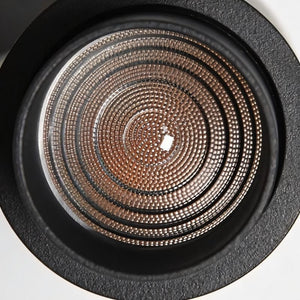 Recessed downlight with concentric copper mesh reflector and black trim ring on white background.