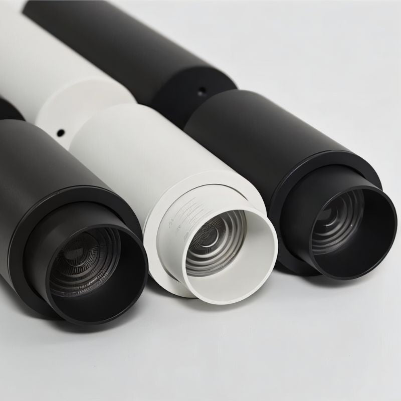 Three cylindrical downlights in black and white finishes displayed against a neutral background.