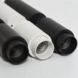 Three cylindrical downlights in black and white finishes displayed against a neutral background.