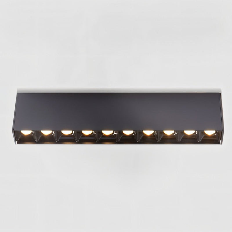 Black linear downlight fixture with ten integrated lights mounted horizontally on white wall.