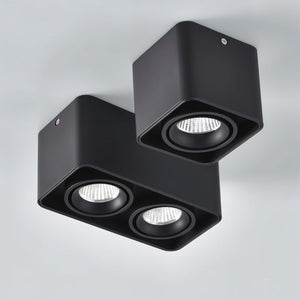 Black adjustable downlight fixtures with three LED spotlights mounted on white ceiling.