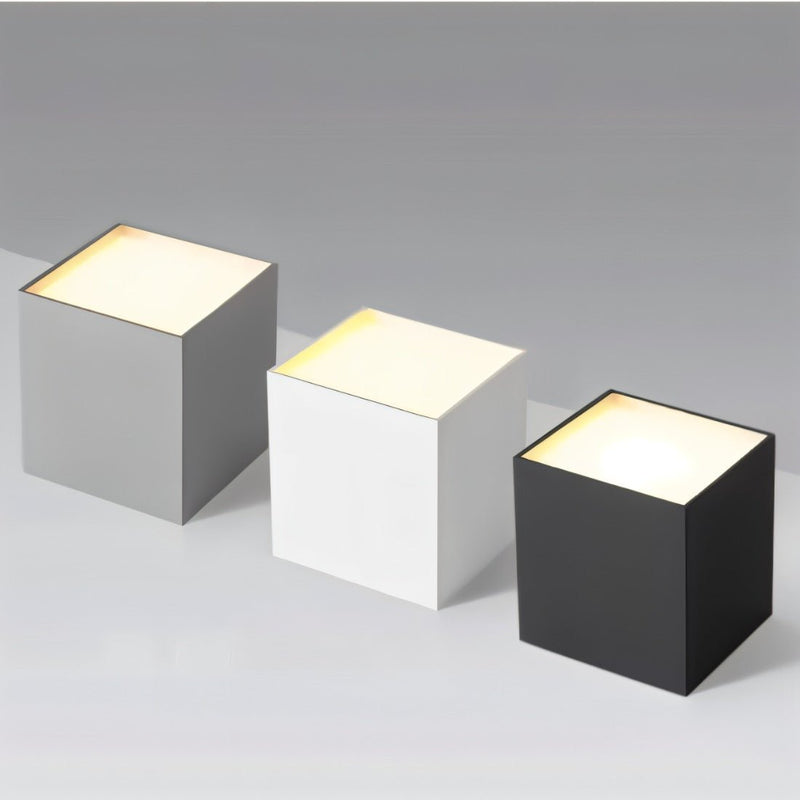 Three illuminated downlight fixtures in gray, white, and black finishes displayed on a neutral background.