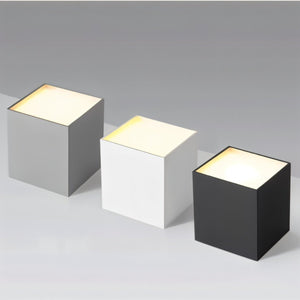 Three illuminated downlight fixtures in gray, white, and black finishes displayed on a neutral background.