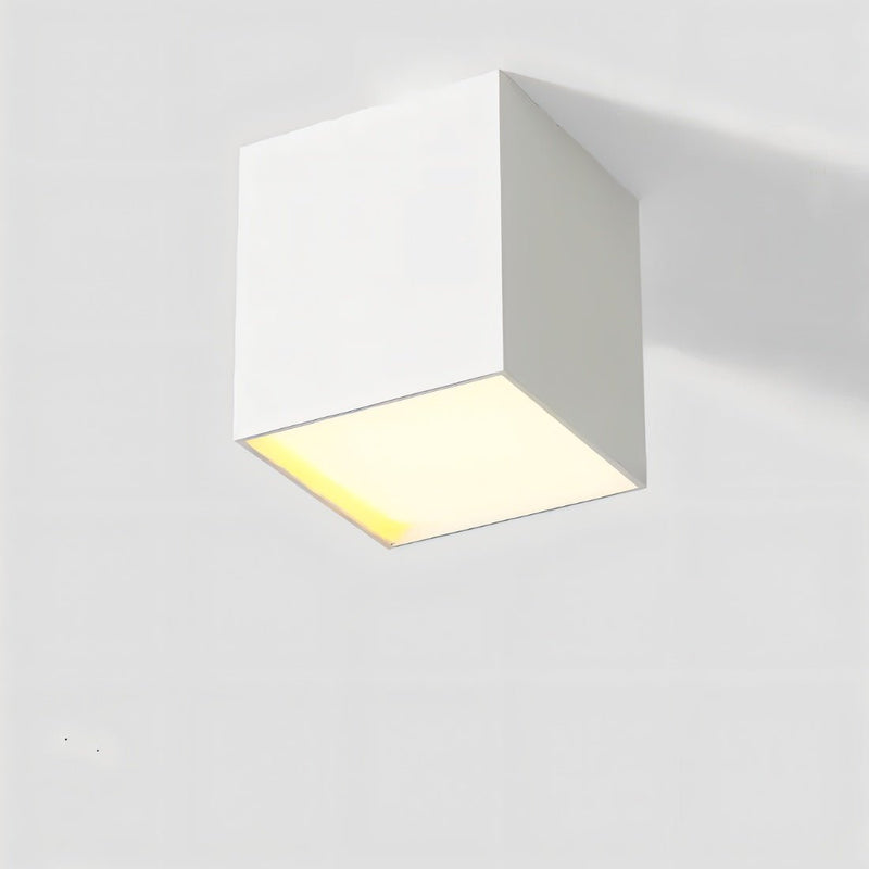 White square ceiling downlight with warm LED glow on neutral background.