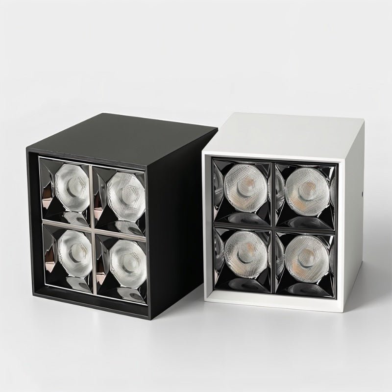 Cube-shaped downlight fixtures in black and white finishes with four recessed LED spotlights on gray background.