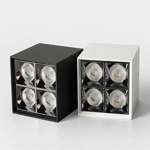 Cube-shaped downlight fixtures in black and white finishes with four recessed LED spotlights on gray background.