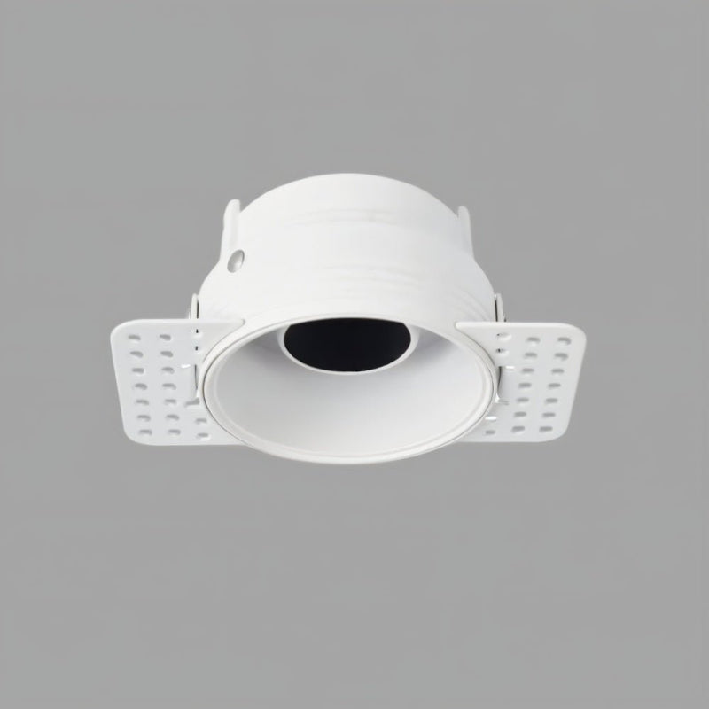 White recessed downlight with adjustable trim and perforated mounting wings on gray background.