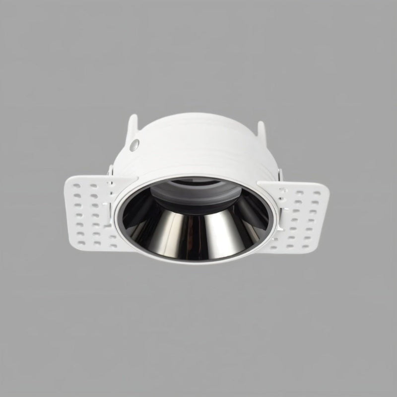 White recessed downlight with black reflector and adjustable trim flanges on gray background.