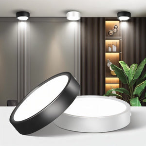 Black and white round LED downlights displayed on a white surface in a modern interior setting.