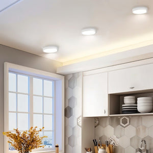Recessed ceiling downlight with white finish installed in modern kitchen with hexagonal tile backsplash.