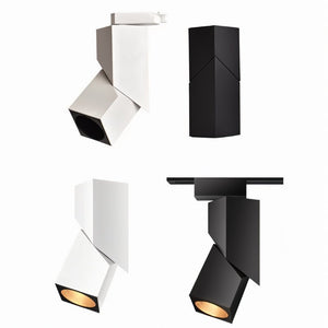 Four white and black adjustable track light fixtures shown from different angles with visible warm-toned apertures.