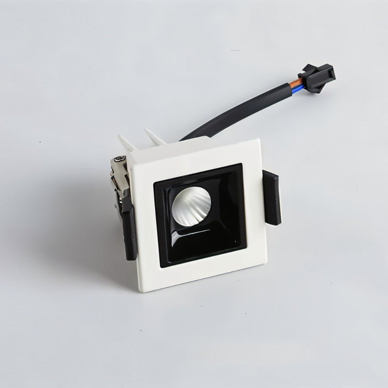 White square recessed downlight with black trim and attached electrical connector on gray background.