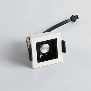 White square recessed downlight with black trim and attached electrical connector on gray background.