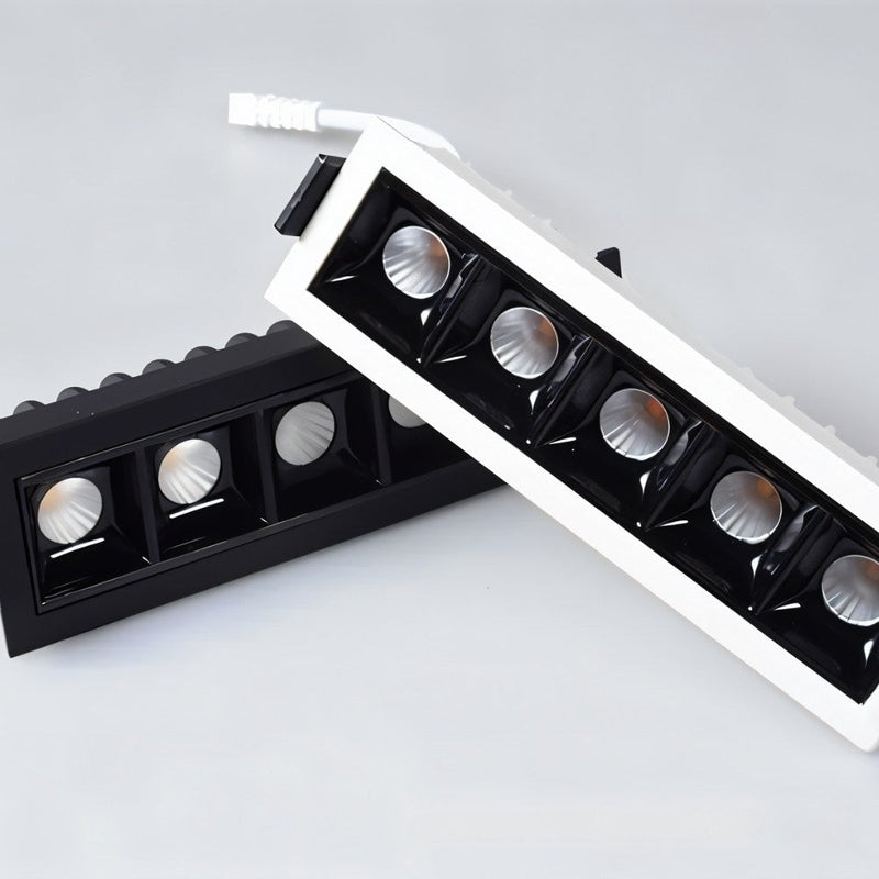 Two recessed downlights with black and white trim and reflective silver fixtures displayed on white background.