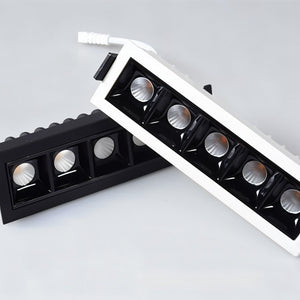 Two recessed downlights with black and white trim and reflective silver fixtures displayed on white background.