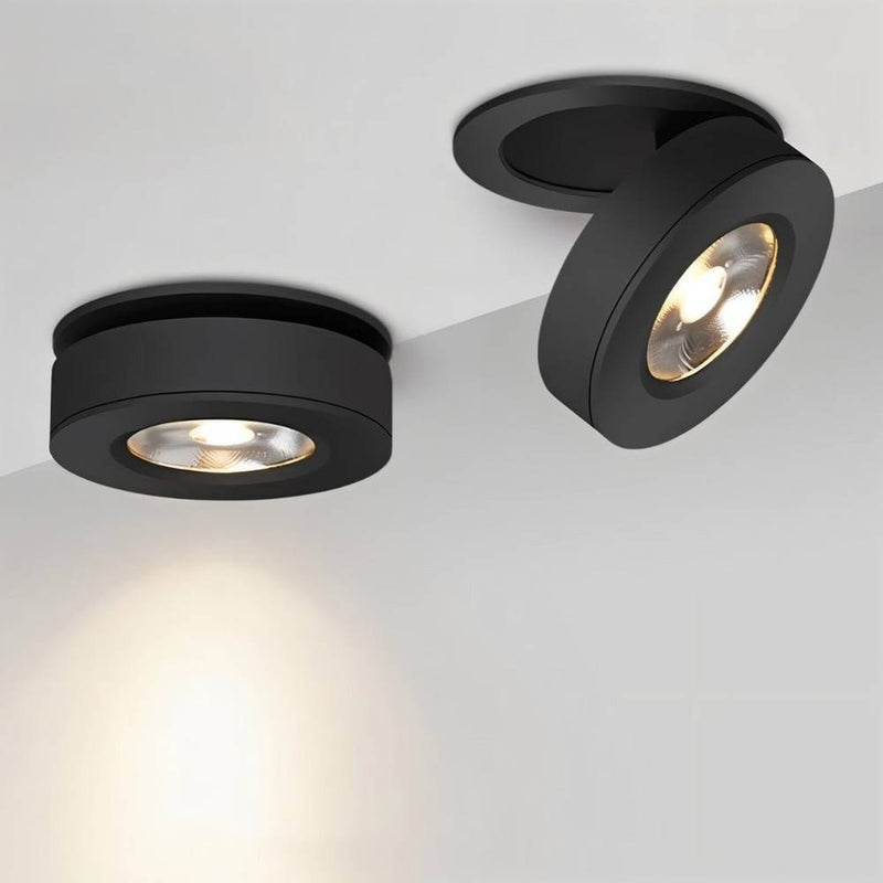 Two black recessed ceiling downlights with warm LED bulbs mounted on a white ceiling.