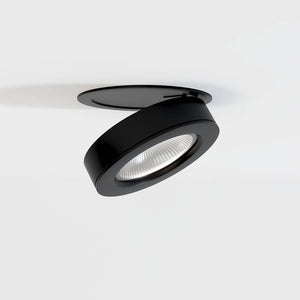 Black adjustable recessed downlight with LED lens mounted in white ceiling.
