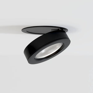 Black adjustable recessed downlight with reflector lens mounted in white ceiling.