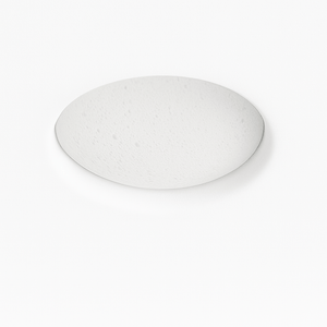 Illuminated circular wall light with warm glow, textured surface, mounted on white wall above gray sofa in modern interior se
